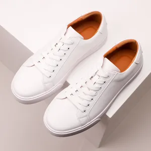 Detail view of premium white leather sneakers with soft orange interior lining