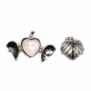 Detailed view of vintage silver angel wing locket with open heart and pink rose quartz stone