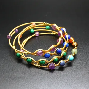 Vista dettagliata di bracciali a filo in oro 14K con pietre preziose e naturali.