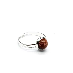 Dettaglio di un anello regolabile in argento con una pietra di avventurina marrone