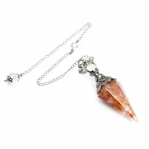 Macro view of a resin hexagonal cone pendulum with garnet stones and silver chain.