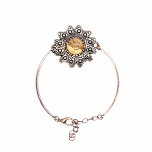 Nahaufnahme eines antiken Kupfer-Blumenarmbands mit rundem Naturstein für elegante Damen