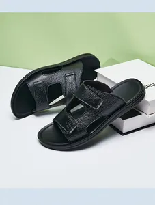 Macro view of premium black leather men's slide sandals with textured straps and tag