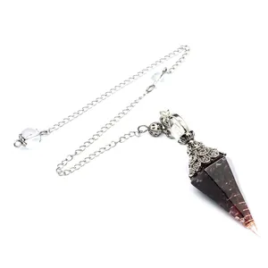Macro view of handcrafted garnet resin pendulum with copper coil and vintage silver chain