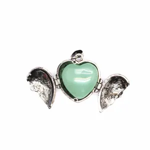 Close-up of open angel wing heart pendant with polished green natural stone