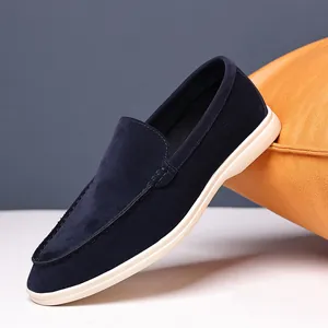Close-up detail view of navy blue suede slip-on loafer for men featuring a white sole