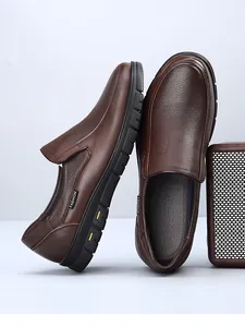 Detail view of brown genuine leather men's slip-on loafers with textured finish.