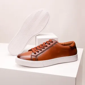 Premium brown genuine leather men's casual sneakers shown with thick white durable rubber soles.