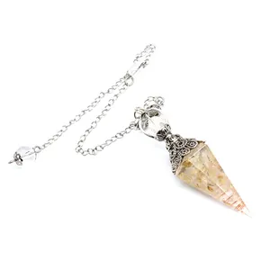 Close-up of hexagonal crystal dowsing pendulum with citrine chips in resin