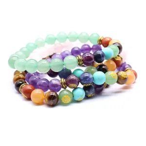 Close-up of 8mm natural stone 7 Chakra beaded bracelets with engraved gold symbols