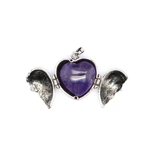 Macro shot of an open vintage angel wings heart locket pendant with purple stone