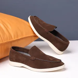Detailed view of brown suede loafers showing texture and stitching on white background