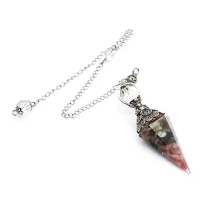 Detail view of a hexagonal resin dowsing pendulum filled with colorful chakra stones