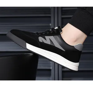 Detail of vintage black men's casual sneaker with white thick sole and grey M logo.