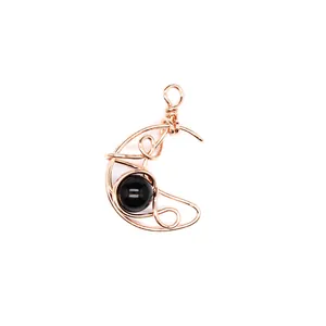 Detailed view of hand-woven rose gold crescent moon pendant with black stone