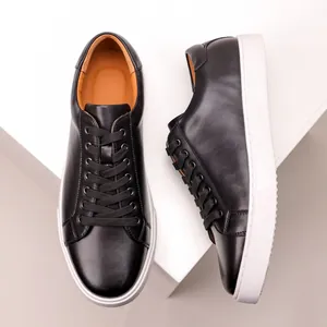 Minimalist black leather sneakers with thick white soles and cowhide texture.