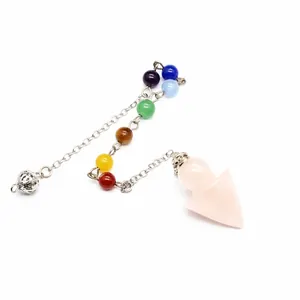 Close-up of rose quartz arrow pendulum with seven chakra stones on a silver metal chain