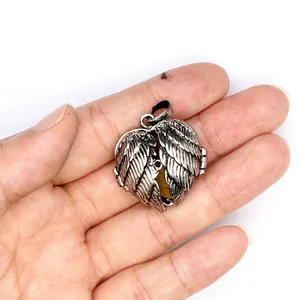 Detailed view of vintage angel wings heart locket pendant with tiger eye stone