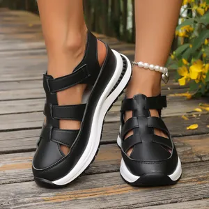 Close-up of black hollow-out platform wedge sandals with adjustable Velcro strap
