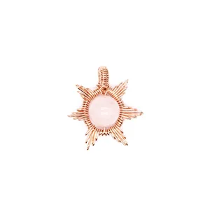 Detailed macro view of hand-woven rose gold sunburst pendant with natural pink stone