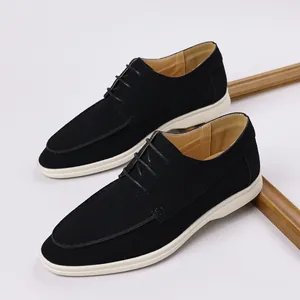 Top view of black suede casual shoes with contrasting white soles and laces.