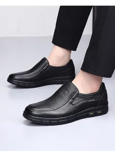 Close-up of men's black genuine leather slip-on loafers with textured finish and rubber sole.