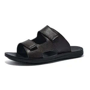 Macro view of men's dark brown textured leather slides featuring adjustable dual velcro straps