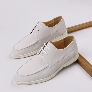 Detail of men's light grey suede lace-up casual shoes with a clean white rubber sole.