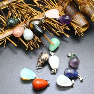 Close-up of diverse teardrop-shaped natural stone crystal pendants on bamboo background.
