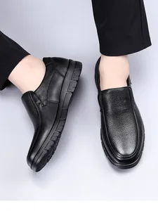 Close-up detail of premium black genuine leather loafers with textured finish design.