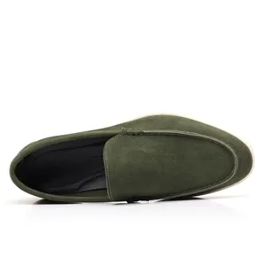 Macro view of green suede men's loafers showing top stitching and interior detail.