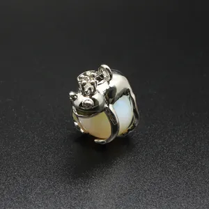 Close-up of a silver Frog Prince pendant hugging a white translucent natural stone sphere