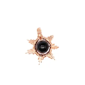 Detailed macro view of hand-woven sun shape pendant featuring black natural stone inlay