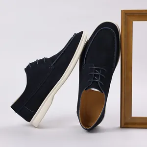 Detail view of navy blue suede lace-up loafers featuring a contrasting white sole