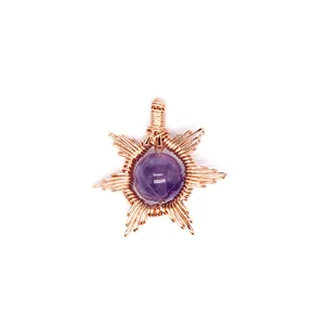 Close-up detail of a handmade wire-wrapped sun pendant with purple gemstone bead