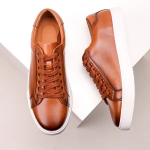 Detailed view of brown leather sneakers with thick white soles and classic laces