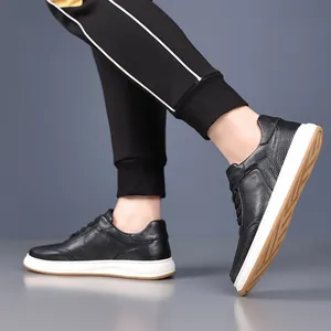 Close-up of black textured cowhide leather sneakers featuring white midsoles and tan outsoles.