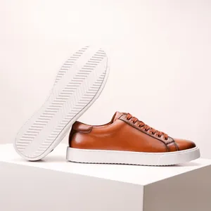 Detail of brown cowhide leather sneakers with a thick white anti-slip rubber sole.