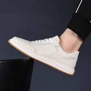 Detail view of premium white leather men's sneakers featuring durable brown sole