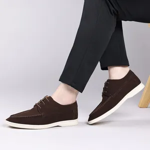 Detailed view of brown suede loafers with white rubber soles and lace-up design