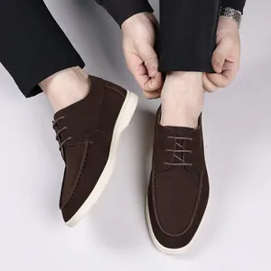 Top-down view of brown suede lace-up loafers featuring contrast white soles for men