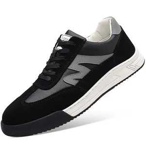 Close-up of men's retro German trainer shoes in black and grey leather with a thick white sole.