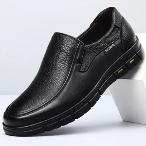 Close-up view of black genuine leather men's slip-on casual shoes featuring textured finish and durable sole.