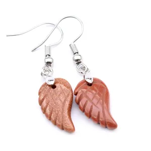 Detalle de pendientes con forma de ala de piedra de sol marrón y ganchos de plata fina