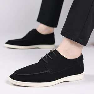 Detailed side view of black suede lace-up casual shoes with white sole on model