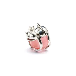 Detailed macro view of a silver frog prince pendant hugging a translucent pink crystal ball