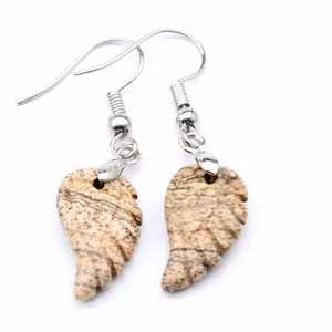 Detalle de pendientes de piedra natural con un diseño único de ala tallada