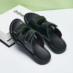 Macro view of men's black slides featuring textured leather and adjustable straps