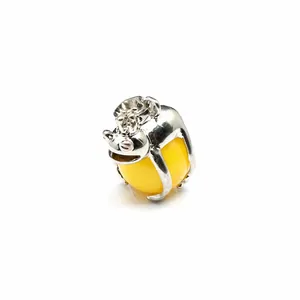 Close-up of a silver frog prince pendant holding a polished yellow natural stone bead