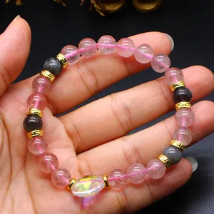 Detailed close-up of a pink strawberry quartz beaded bracelet with gold accents